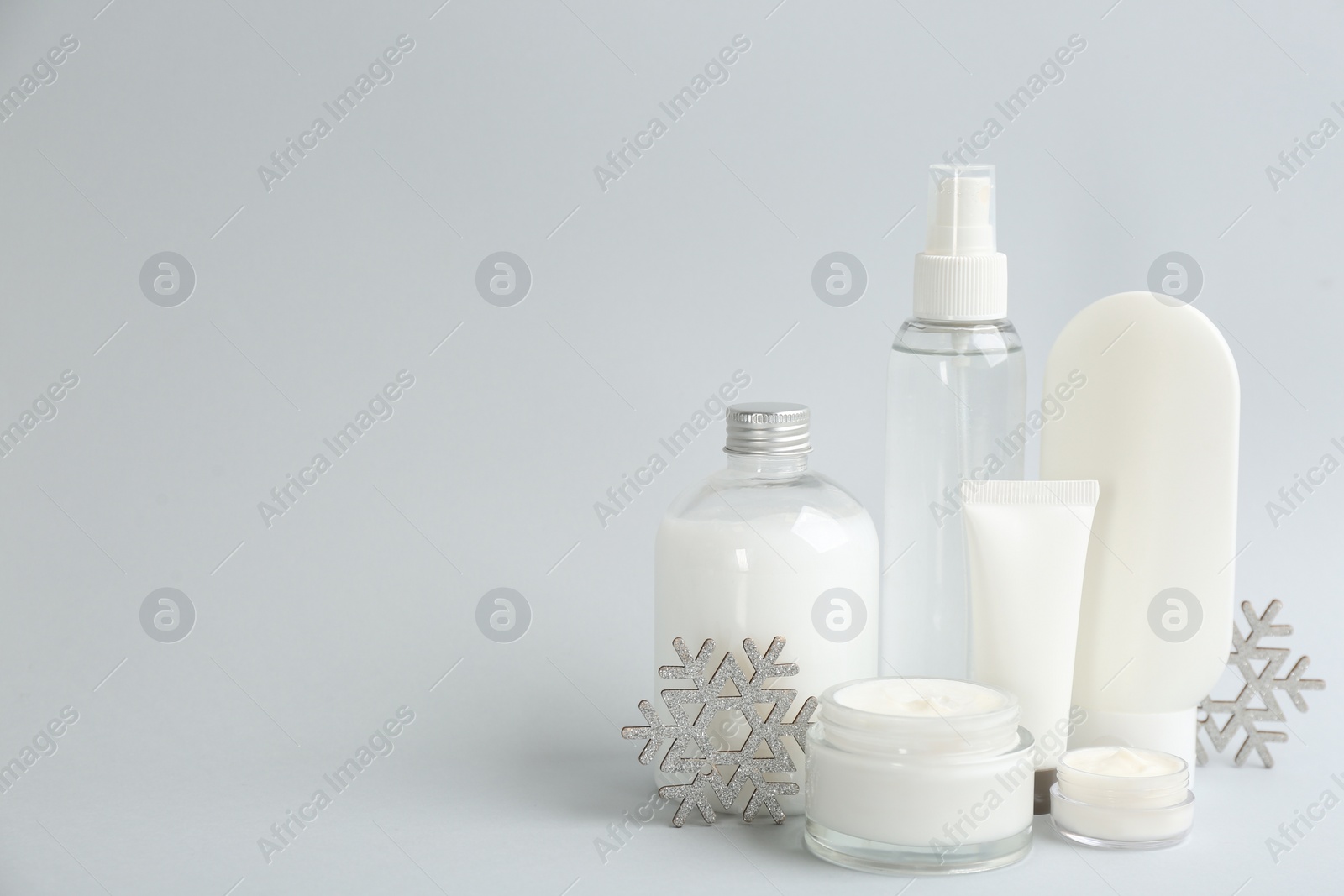 Photo of Beautiful composition with cosmetic products on light grey background, space for text. Winter care