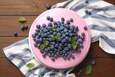 Photo of Tasty blueberry cake and napkin on wooden table, flat lay