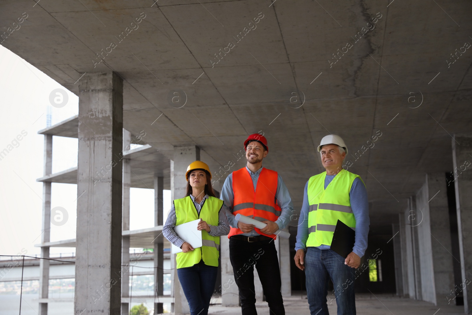 Photo of Professional builder and foreman in safety equipment at construction site