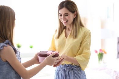 Photo of Teenage daughter congratulating happy woman on Mother's Day at home