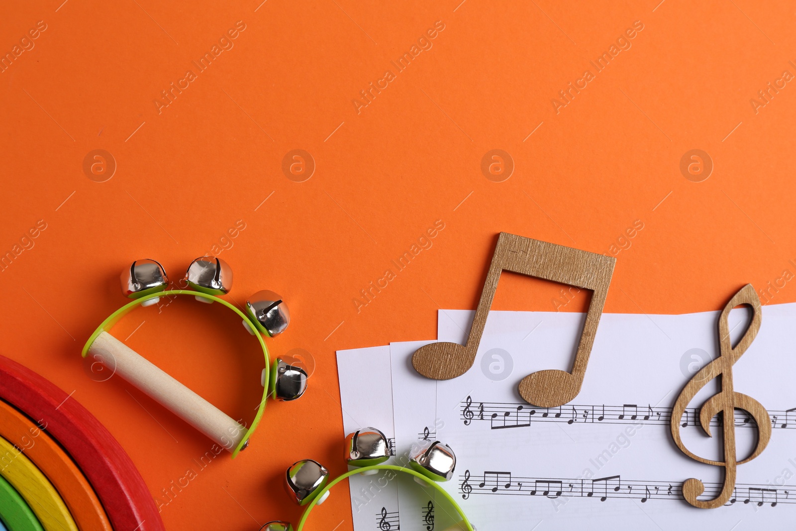 Photo of Tools for creating baby songs. Flat lay composition with tambourines for kids on orange background. Space for text