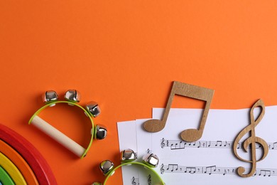 Tools for creating baby songs. Flat lay composition with tambourines for kids on orange background. Space for text