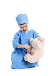 Cute child playing doctor with stuffed toy on white background