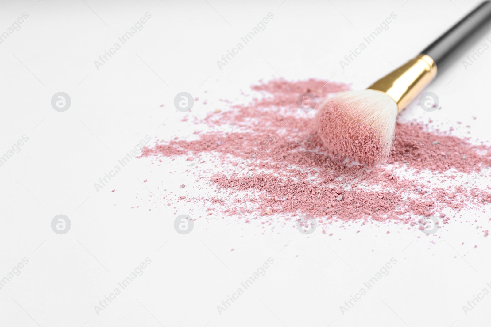 Photo of Makeup brush with crushed cosmetic product on light background. Space for text