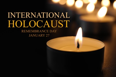 International Holocaust Remembrance Day January  27. Burning candle on table in darkness, closeup