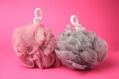 Colorful shower puffs on pink background. Personal hygiene