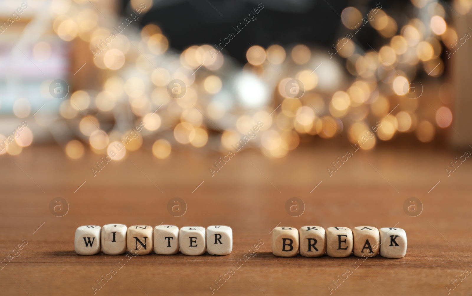 Photo of Cubes with phrase Winter Holidays and blurred Christmas decor on background. Space for text