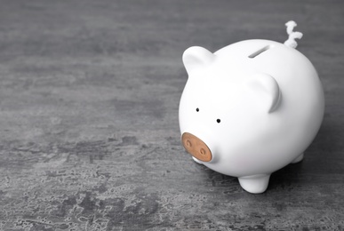 Photo of White piggy bank on gray table. Money saving