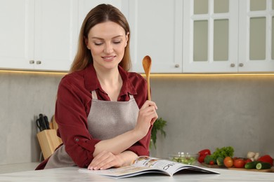 Photo of Woman reading recipe in culinary magazine at home, space for text