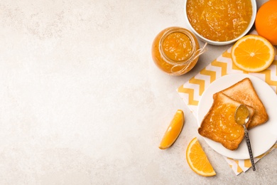 Delicious orange marmalade and toasts on light table, flat lay. Space for text