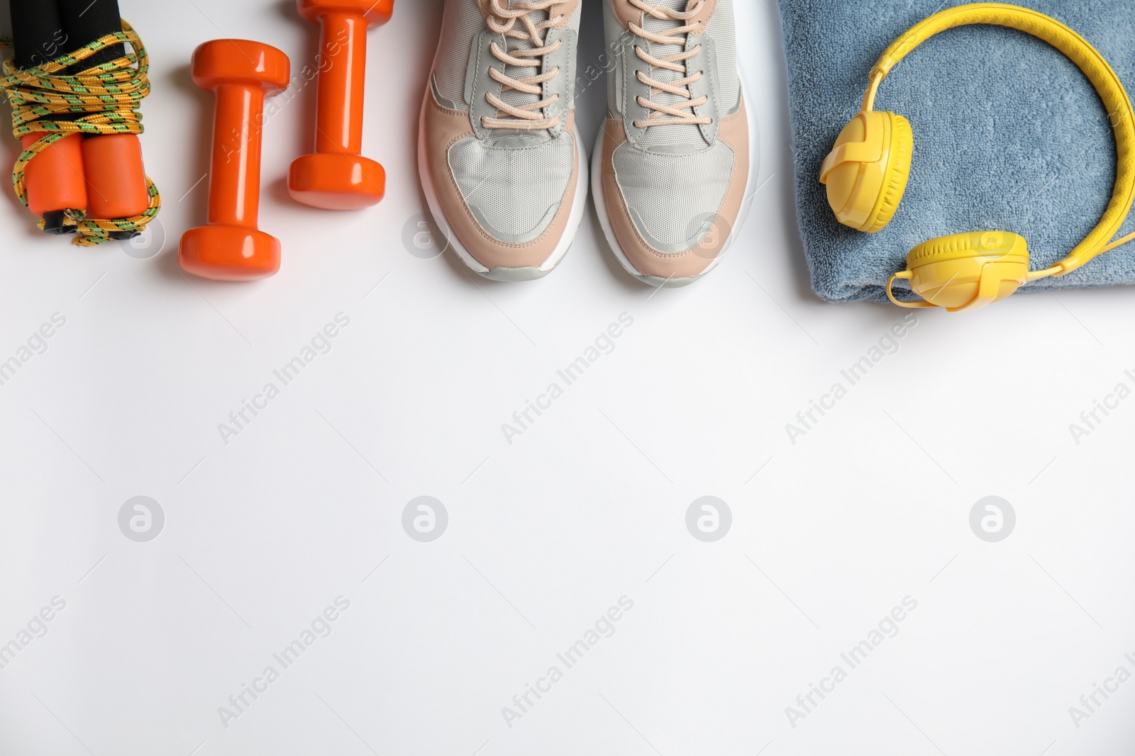 Photo of Flat lay composition with fitness equipment and headphones on white background. Space for text