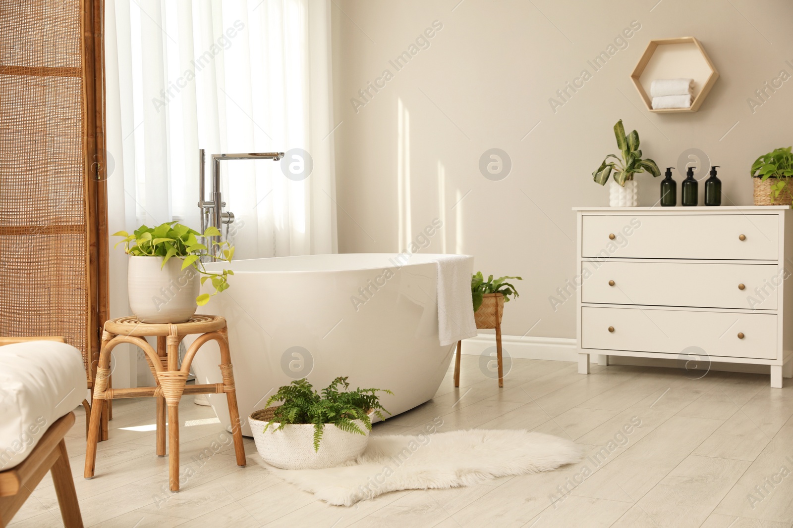 Photo of White tub near window in light room. Interior design