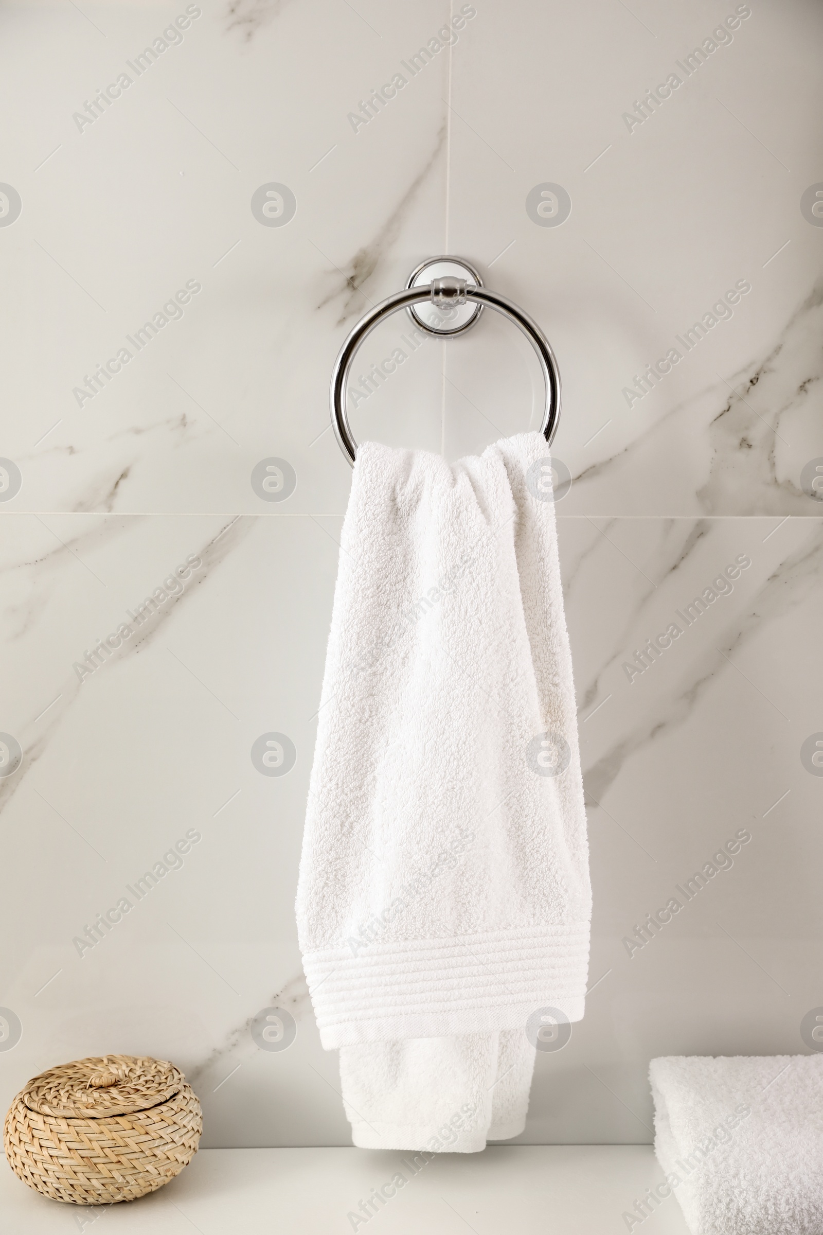 Photo of Holder with clean towel on light wall in bathroom