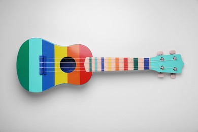 Photo of Colorful ukulele on white background, top view. String musical instrument