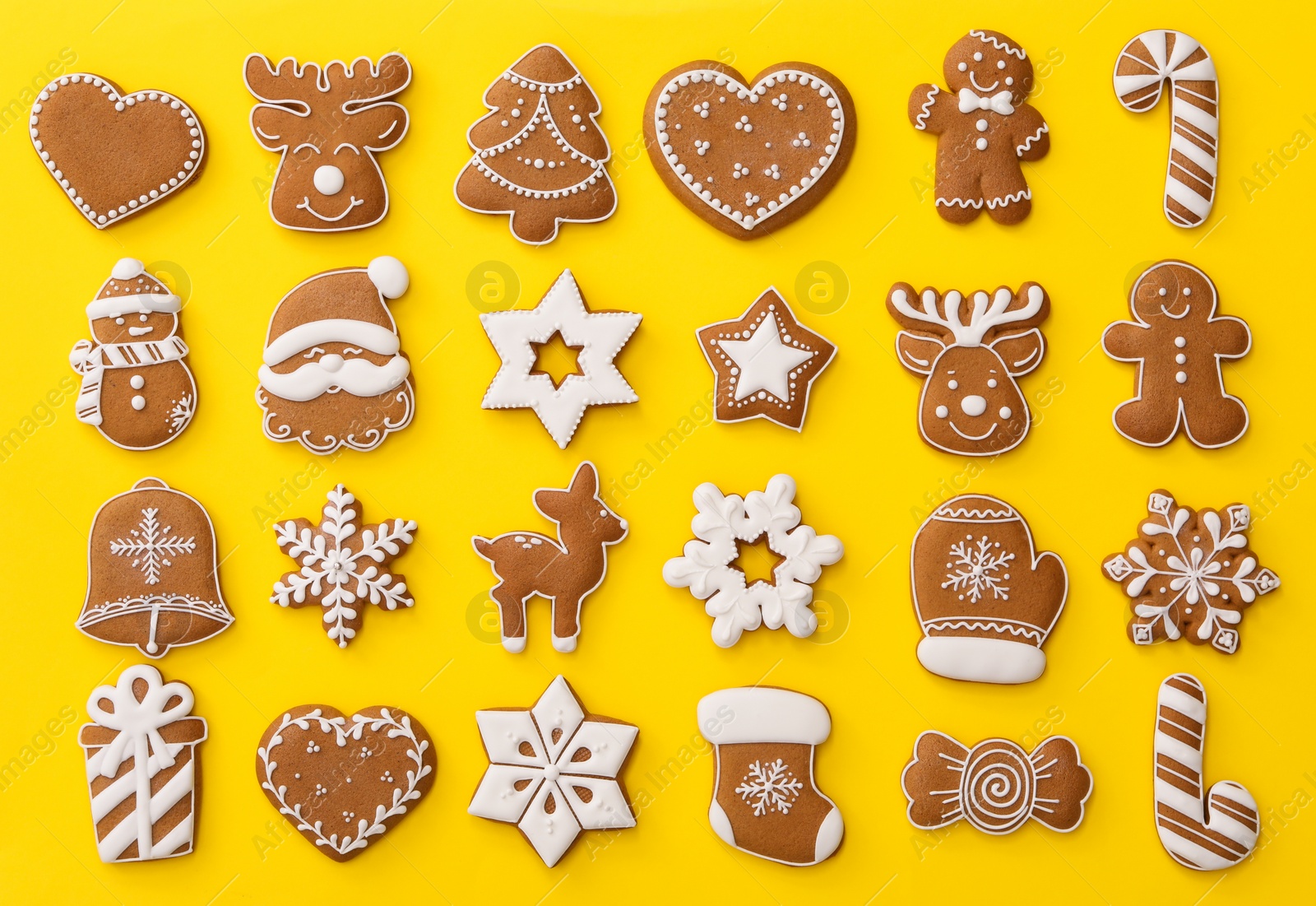 Photo of Different Christmas gingerbread cookies on yellow background, flat lay