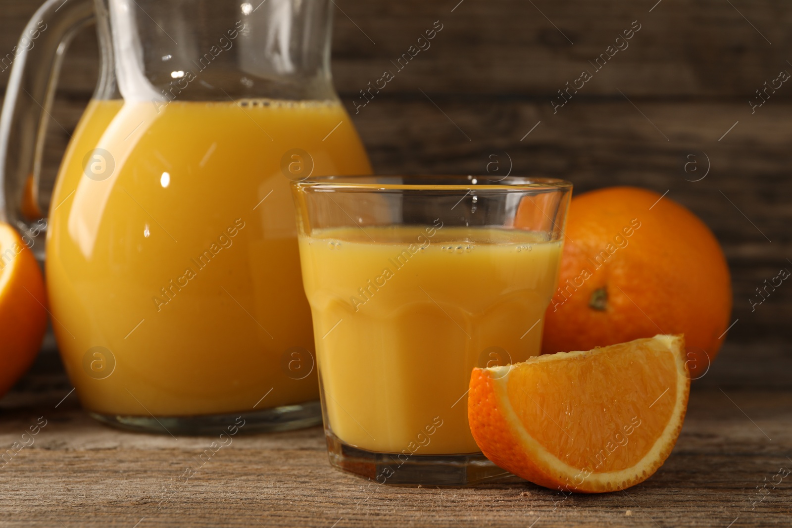 Photo of Tasty fresh oranges and juice on wooden table, closeup