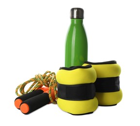 Stylish weighting agents, skipping rope and sport bottle on white background