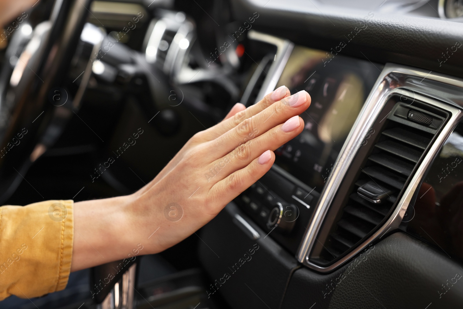 Photo of Woman checking air conditioner in her car, closeup