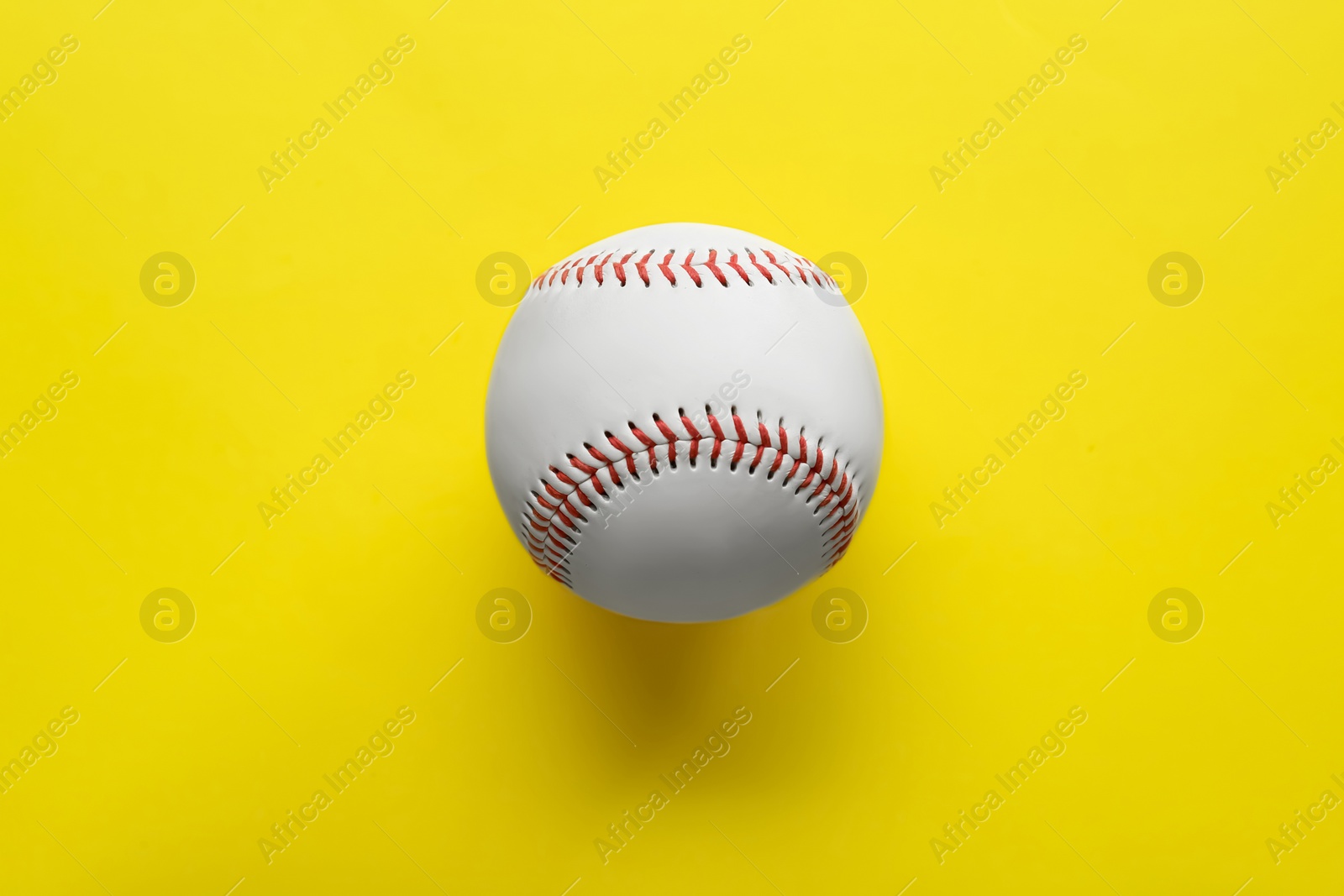 Photo of Baseball ball on yellow background, top view. Sports game