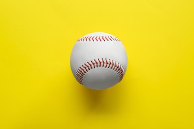 Photo of Baseball ball on yellow background, top view. Sports game