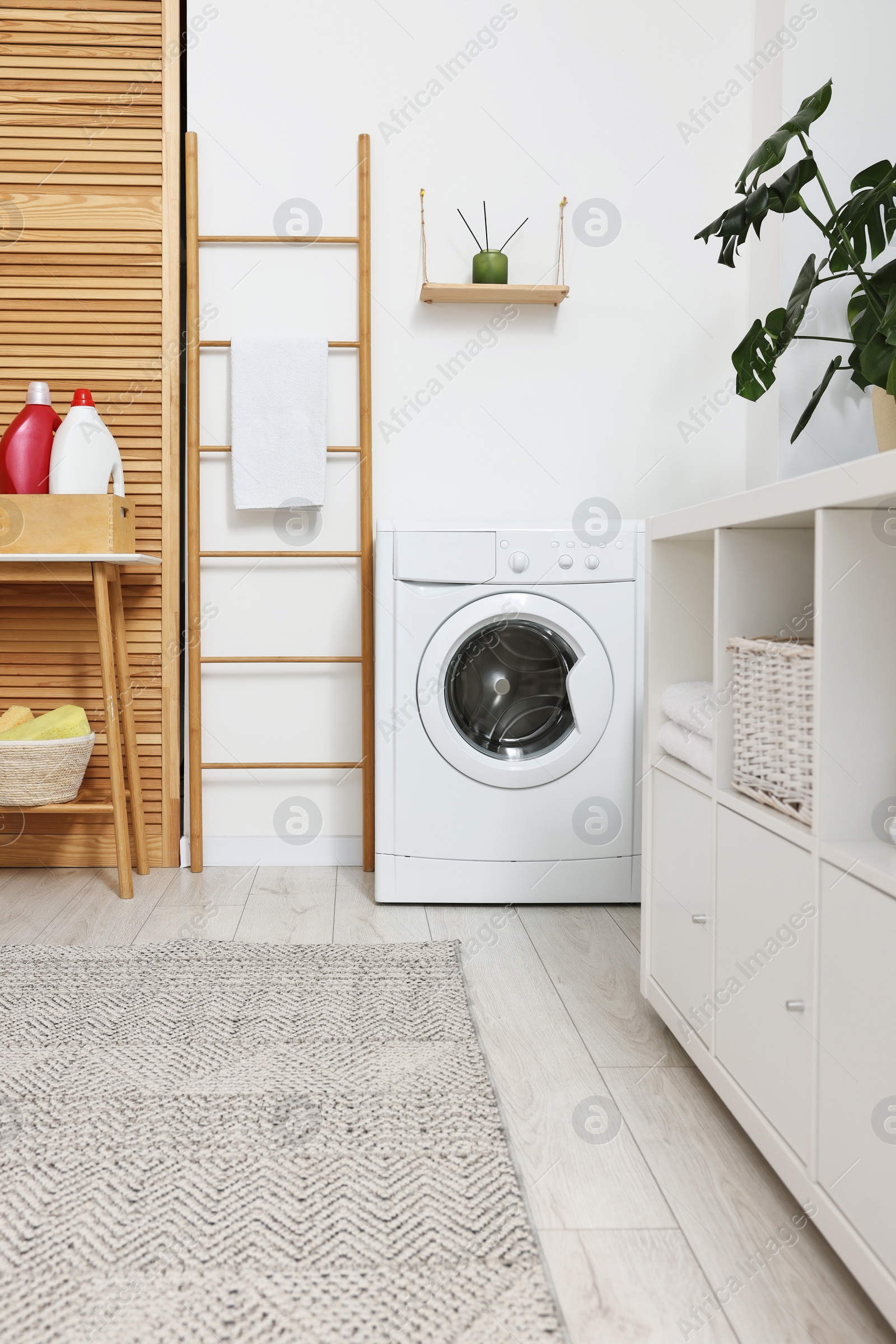 Photo of Laundry room interior with washing machine and furniture