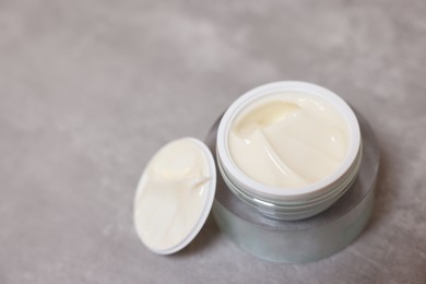 Photo of Body cream on grey table, closeup. Space for text