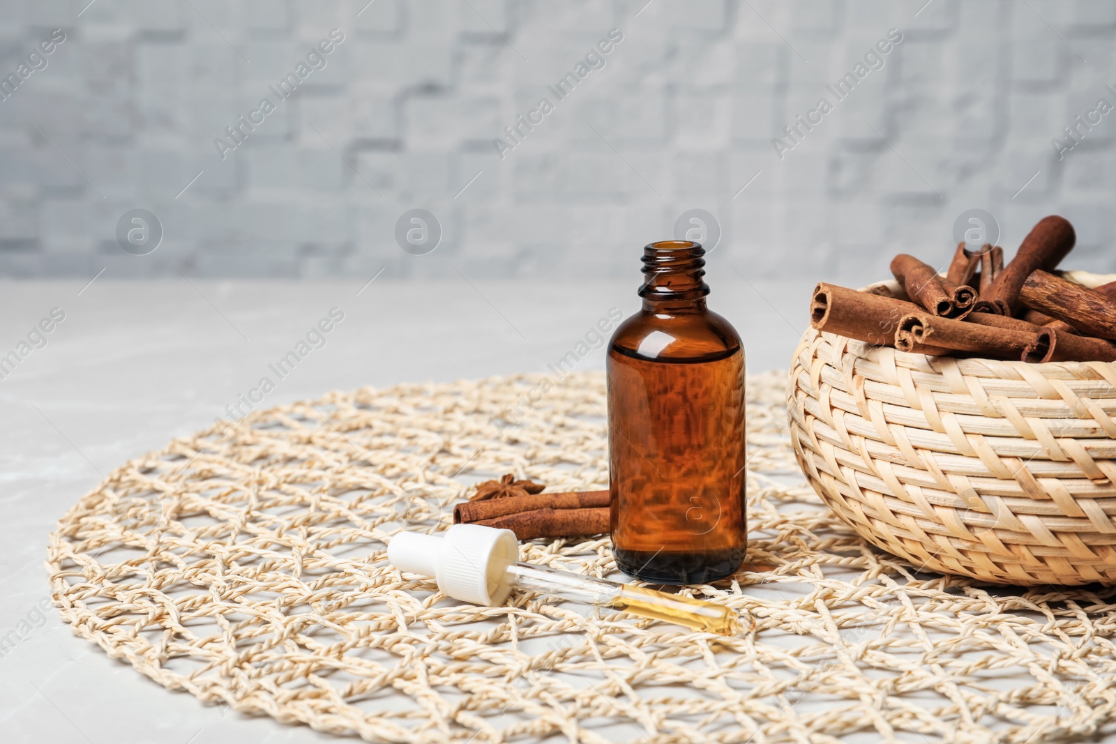 Photo of Bottle with cinnamon oil and sticks on table