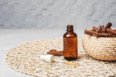 Photo of Bottle with cinnamon oil and sticks on table