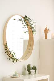 Round mirror on white wall in modern bathroom