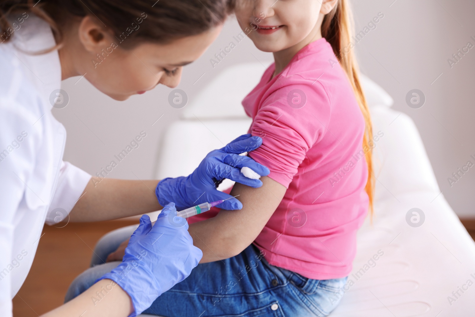 Photo of Little girl receiving chickenpox vaccination in clinic, closeup. Varicella virus prevention