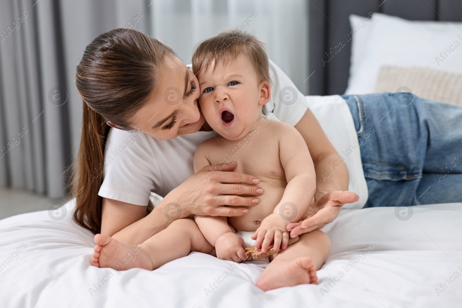 Photo of Happy mother with her baby on bed at home