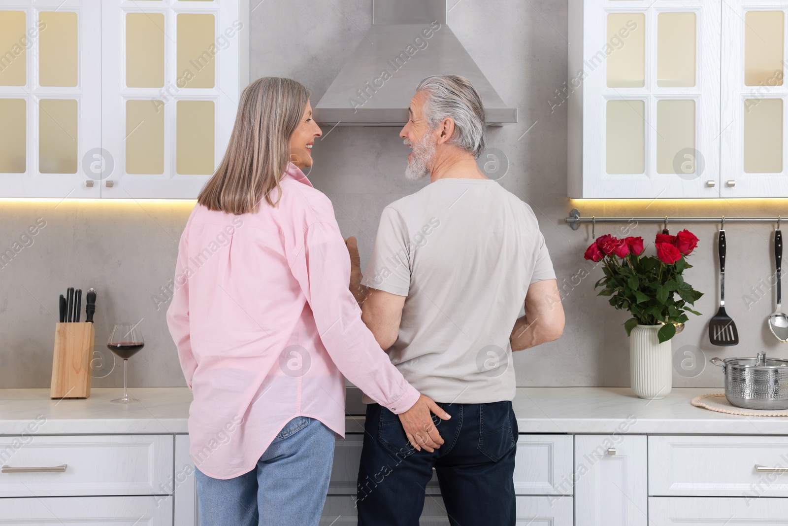 Photo of Affectionate senior couple spending time together in kitchen