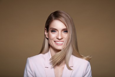 Image of Portrait of stylish attractive woman with blonde hair smiling on pastel brown background