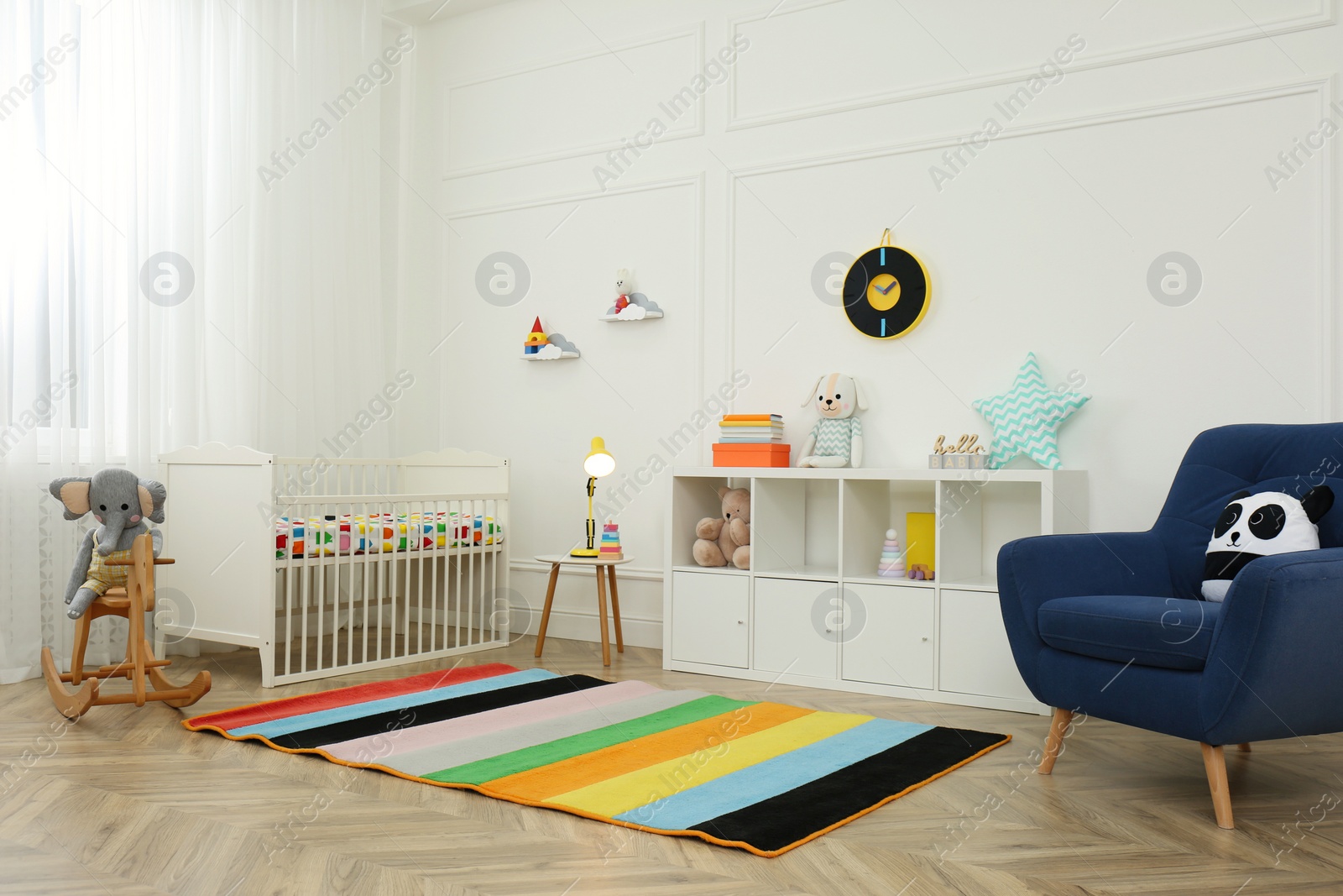 Photo of Cute baby room interior with stylish furniture and toys