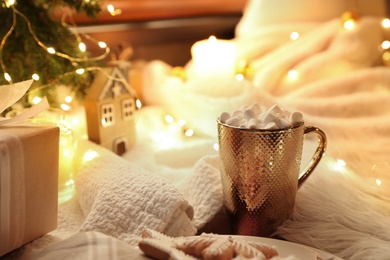 Photo of Cup of hot drink with marshmallows and Christmas cookies at table