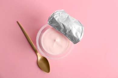 Photo of Plastic cup with tasty yogurt on color background, top view