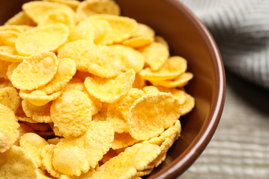 Photo of Tasty crispy corn flakes in bowl, closeup