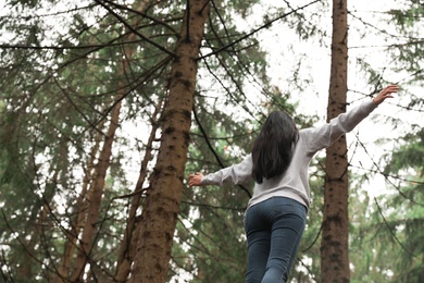 Woman on walk in beautiful coniferous forest