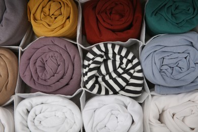 Photo of Different rolled clothes as background, top view. Vertical storage
