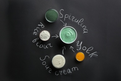 Photo of Spirulina facial mask and ingredients with written names on black background, flat lay