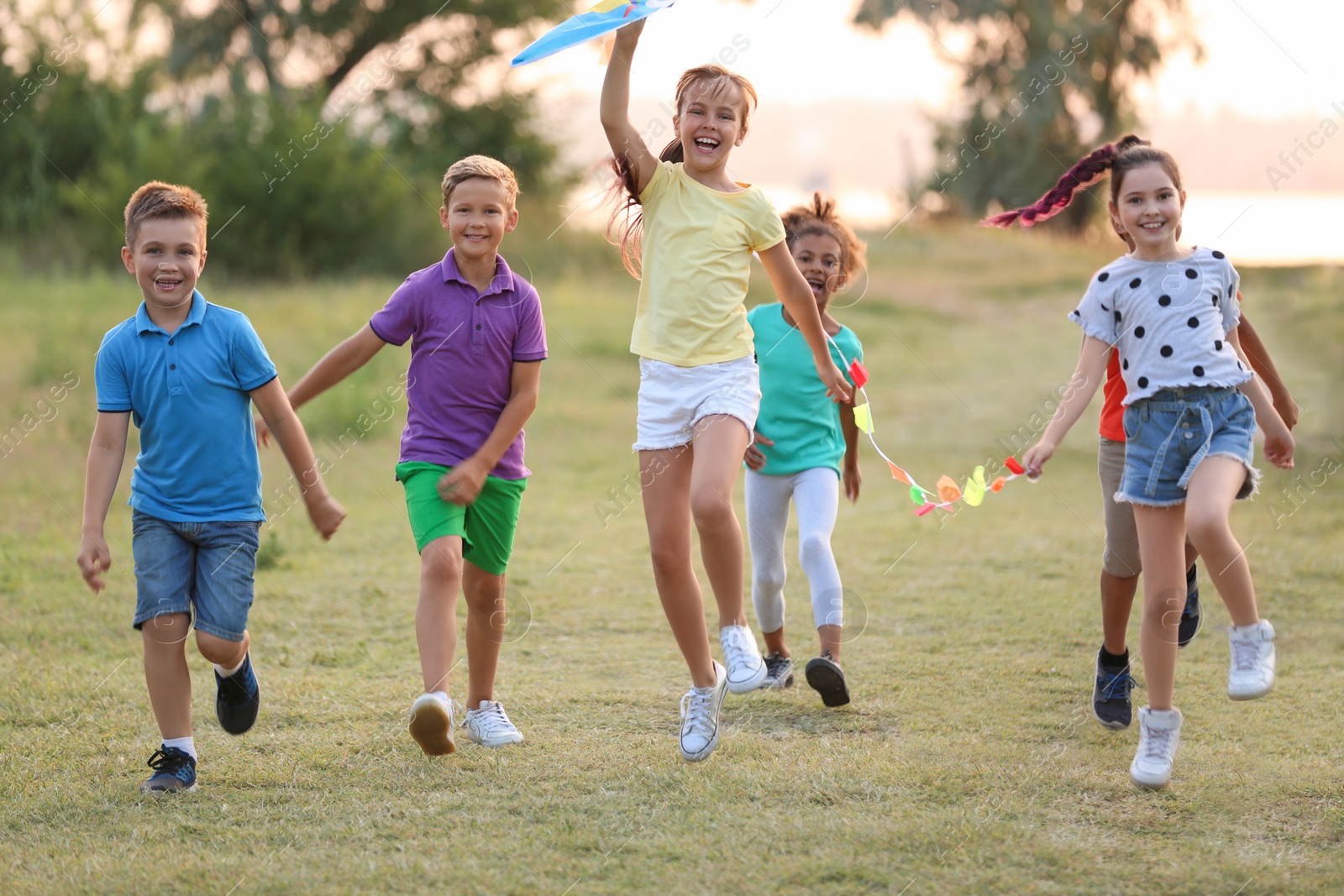 Photo of Cute little children playing with kite outdoors