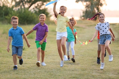 Photo of Cute little children playing with kite outdoors