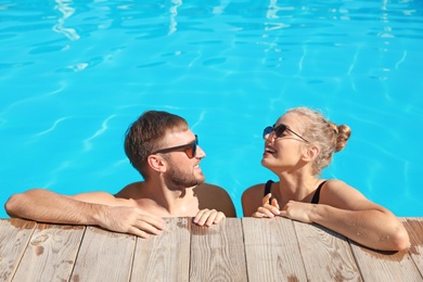 Happy young couple in swimming pool at resort