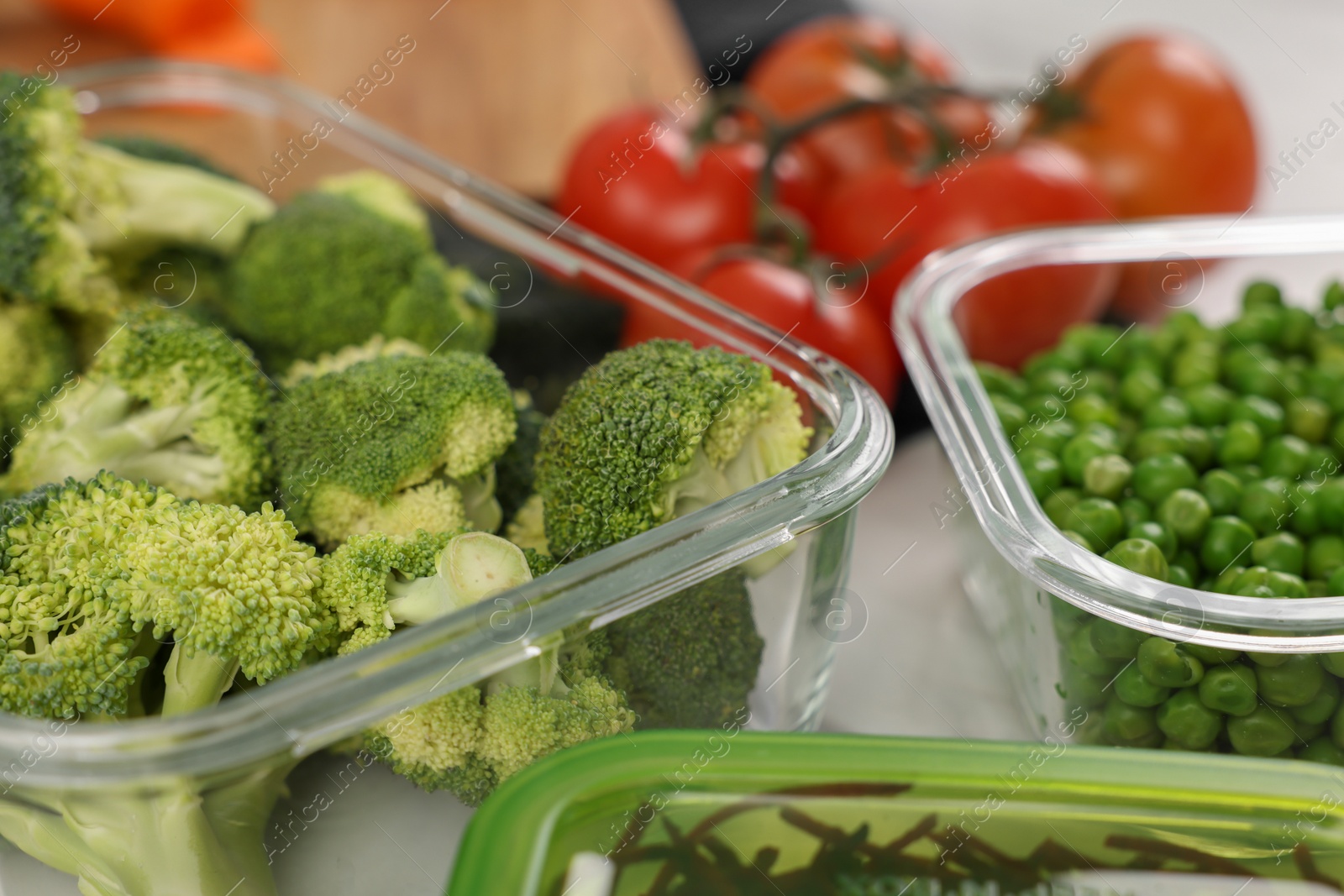 Photo of Containers with broccoli and fresh products on table, closeup. Food storage