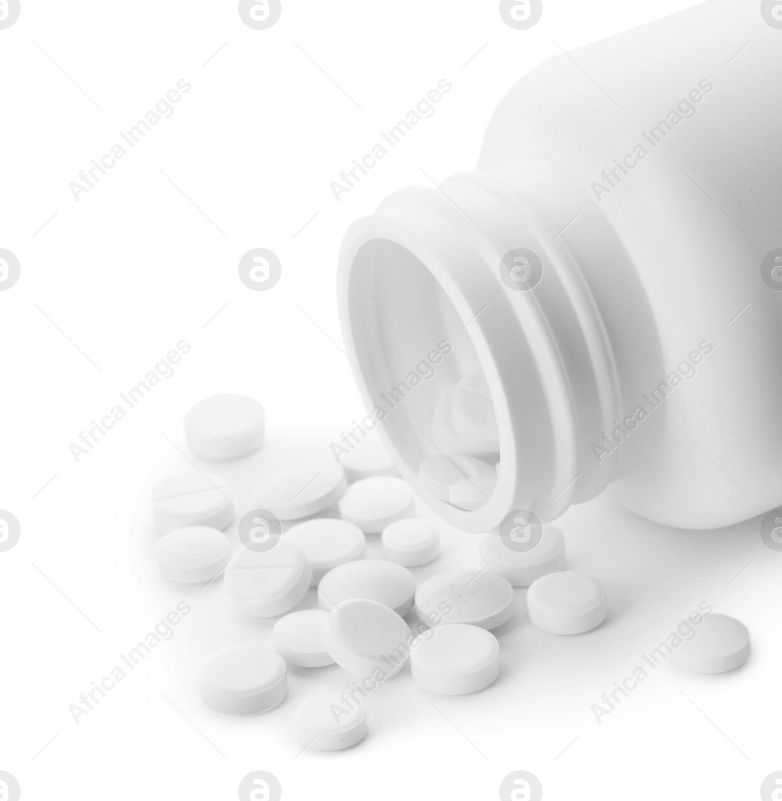 Photo of Scattered pills and open container isolated on white