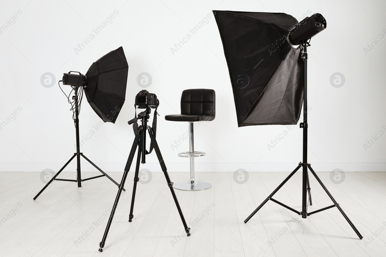 Photo of Empty chair in front of camera and professional lighting equipment indoors. Photo studio set