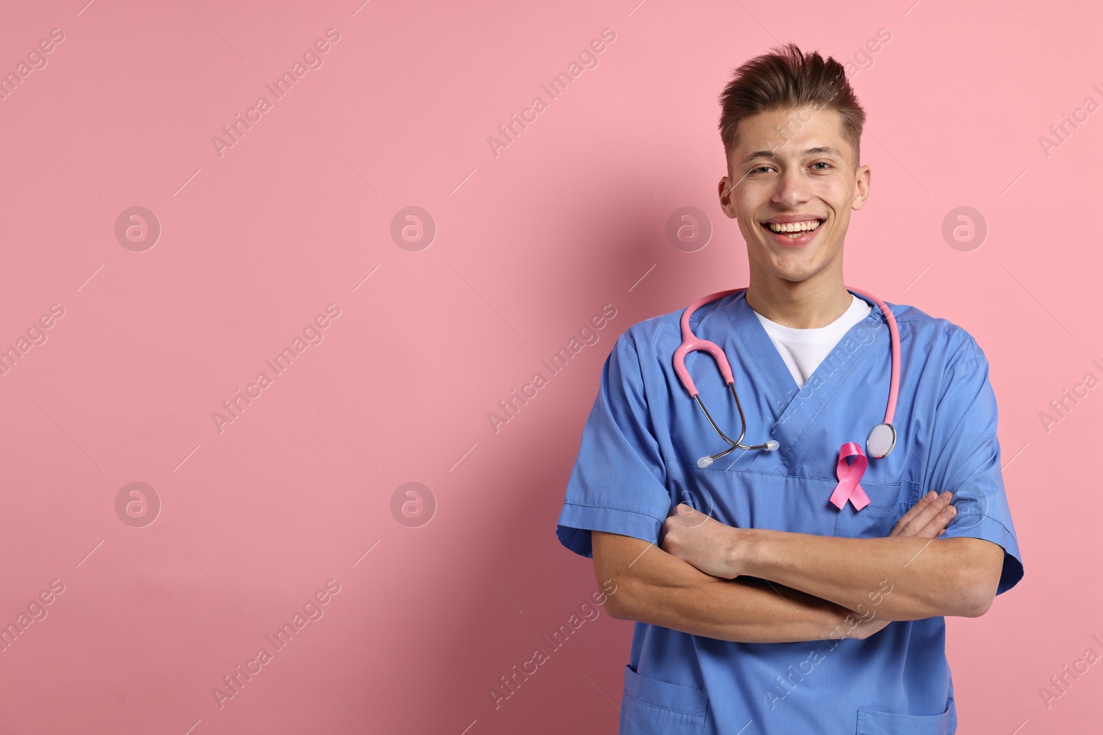 Photo of Mammologist with pink ribbon on color background, space for text. Breast cancer awareness