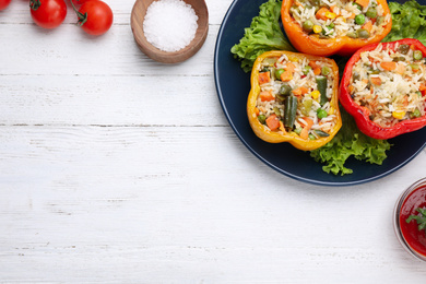 Photo of Tasty stuffed bell peppers served on white wooden table, flat lay. Space for text