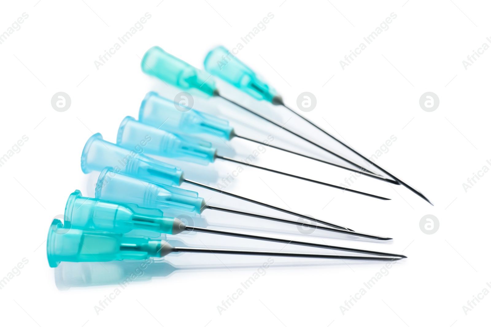 Photo of Many disposable syringe needles on white background