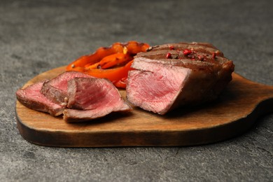 Photo of Delicious grilled beef steak with spices on gray table, closeup